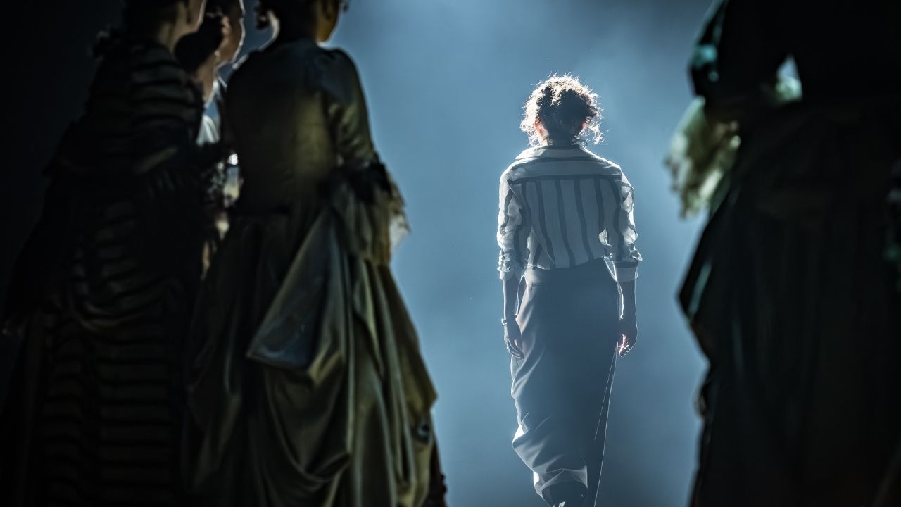 a woman walking out on stage into the light